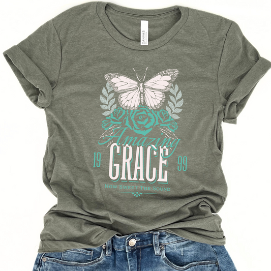 Green graphic t-shirt with 'Amazing Grace' text and a butterfly design, paired with blue jeans.