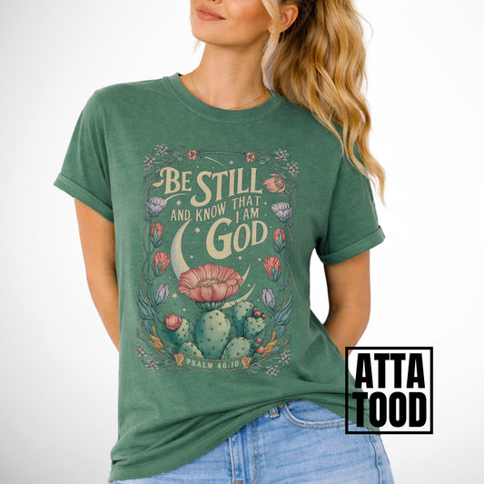 Be still and know that I am God Psalm 46:10 . an oversized blooming cactus plant on an light green comfort colors tee