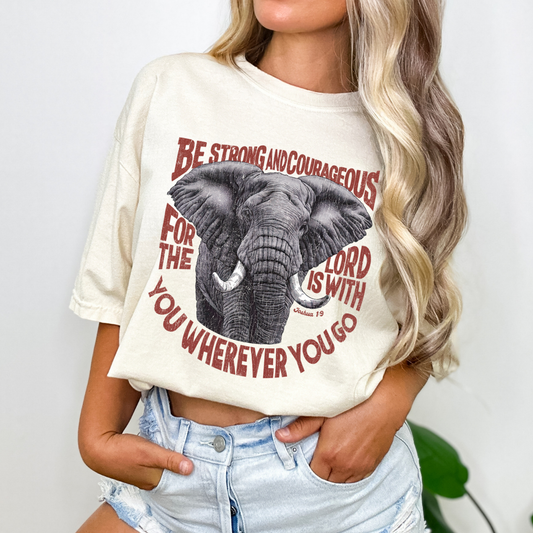 Person wearing a white t-shirt with an elephant graphic and text.  Be strong and courageous for the lord is with you
