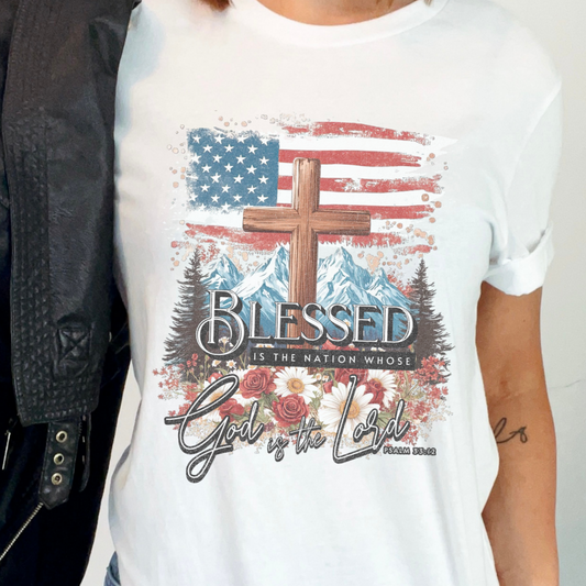 White t-shirt with American flag, cross, mountains, and text design.  Blessed is the nation whose God is the Lord Psalm 33:12