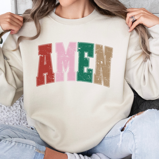 Person wearing a sand color sweatshirt with the word AMEN across the chest in red, green, pink and tan