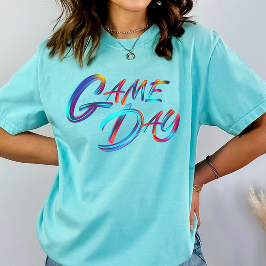 Person wearing a light blue t-shirt with 'GAME DAY' in colorful letters on a plain background