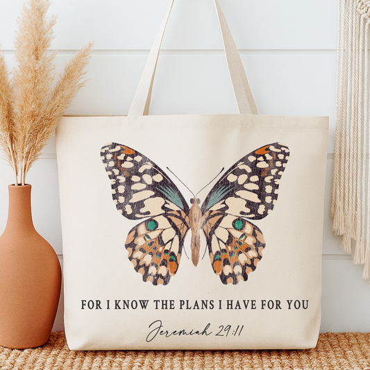 Tote bag with butterfly design and Bible verse text next to a vase with dried plants.  For I know the plans I have for you Jeremiah 29:11