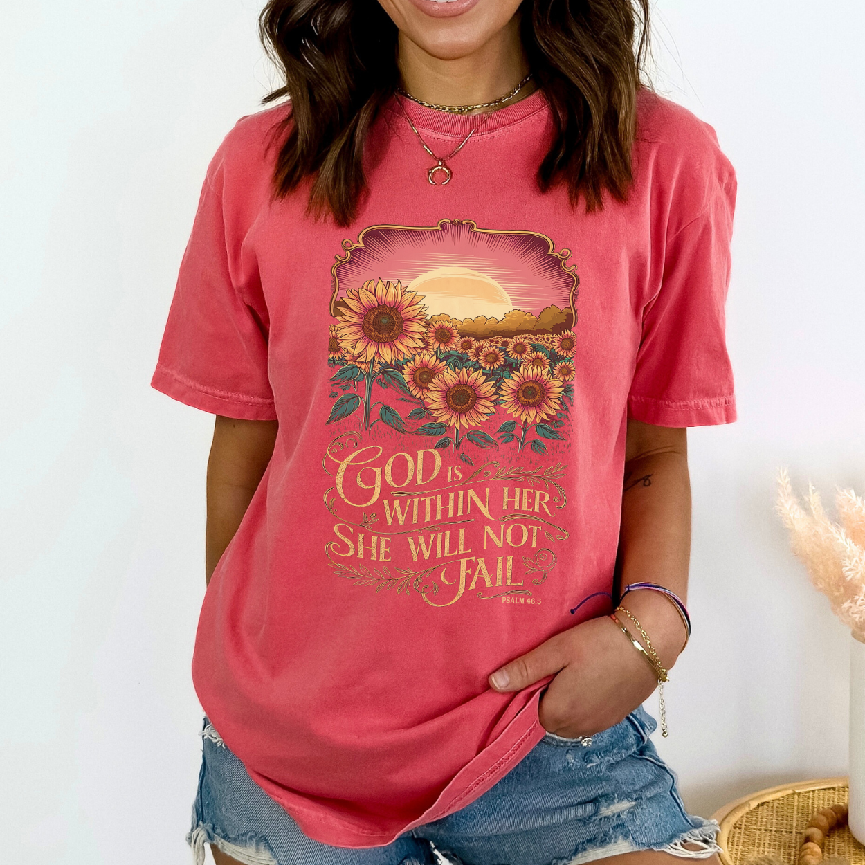 Person wearing a pink t-shirt with a sunflower design and text.  God is within her, She will not Fail Psalm 46:5