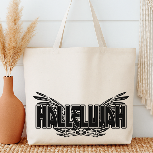 Beige tote bag with 'Hallelujah' design next to a vase with dried plants on a light wooden floor.