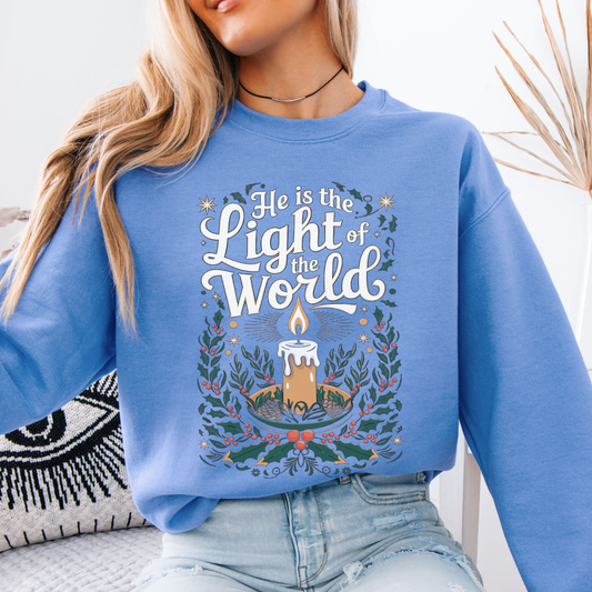 He is the light of the world Christmas Christian blue graphic sweatshirt with a candle in the center of the graphic
