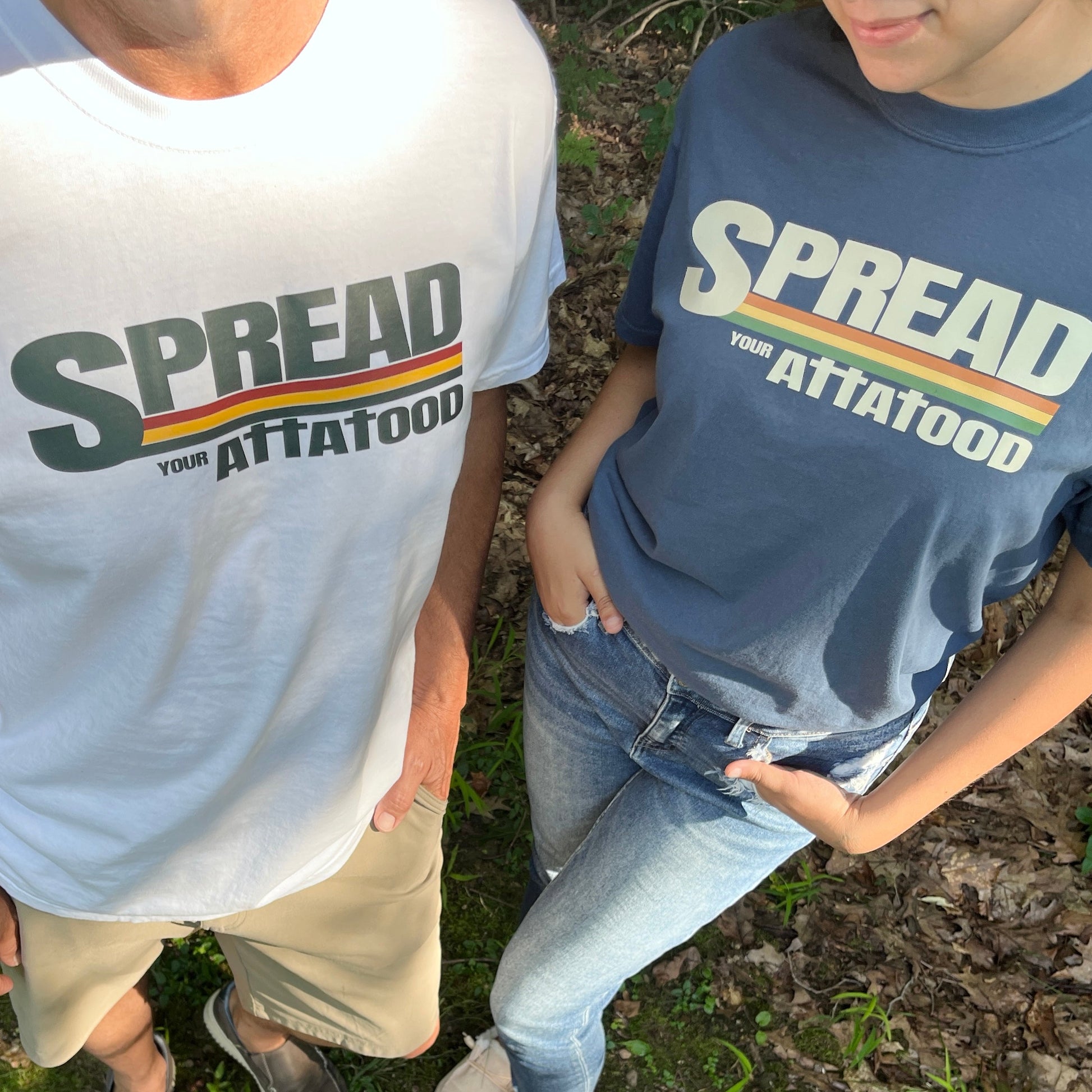 A man wearing a white t-shirt and a woman wearing a blue t-shirt.  comfort colors brand.  The shirt say Spreadyour ATTA TOOD with the t's as crosses