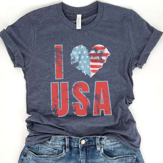 A navy blue t-shirt with a graphic that says 'I love USA' where the word 'love' forms a heart shape with the American flag colors.