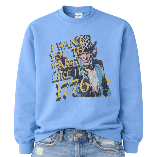 Patriotic Uncle Sam graphic on a blue sweatshirt. The design features a distressed illustrated portrait of Uncle Sam wearing a patterned top hat, paired with bold vintage-style text reading “I Want You to Party Like It’s 1776.” Layered textures, muted patriotic tones, and worn ink details give the artwork a retro Americana feel. A bold, playful patriotic design suited for Fourth of July, summer celebrations, and USA-themed seasonal collections.
