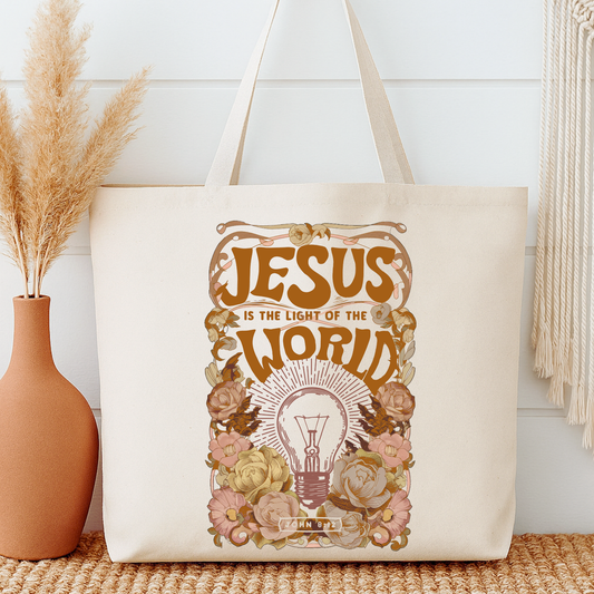 Tote bag with 'Jesus is the Light of the World' design next to a vase and decorative items.