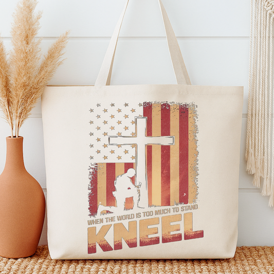 Tote bag with American flag design and text next to a vase on a wooden surface.  When the world is too much to stand, Kneel