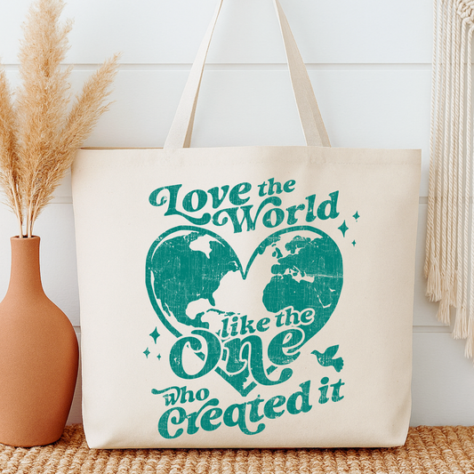 Beige tote bag with teal text and world map design, placed on a wooden surface with decorative elements.  Love the world like the one who created it