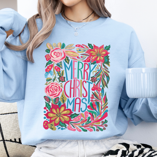 Person wearing a light blue sweatshirt with a colorful 'Merry Christmas' design.