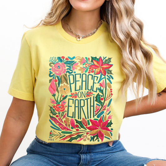 Person wearing a yellow t-shirt with 'Peace on Earth' Boho floral design