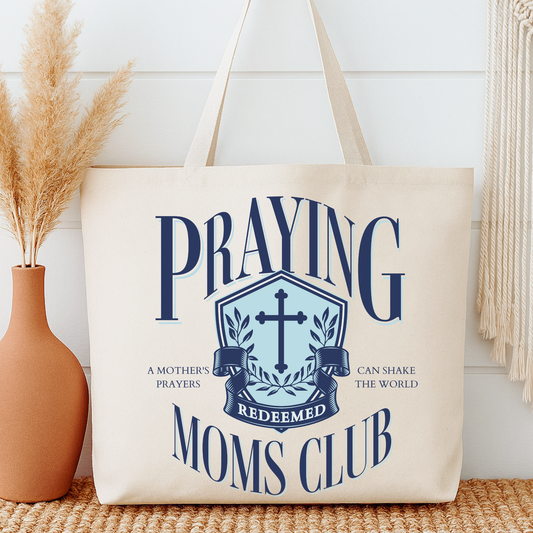Tote bag with 'Praying Redeemed Moms Club' design on a neutral background