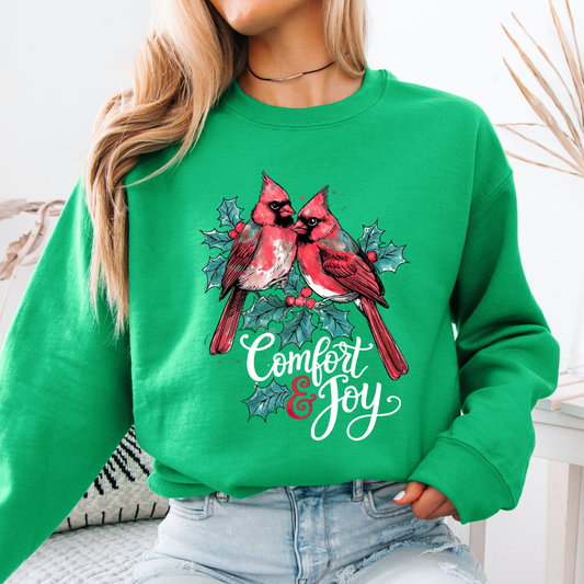 Green sweatshirt with cardinals and 'Comfort & Joy' text worn by a person.