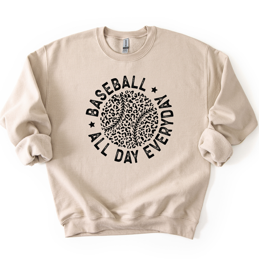 beige crewneck sweatshirt featuring a black circular graphic with a leopard print baseball and curved text reading “Baseball All Day Everyday,” styled flat with sleeves scrunched on a white background.