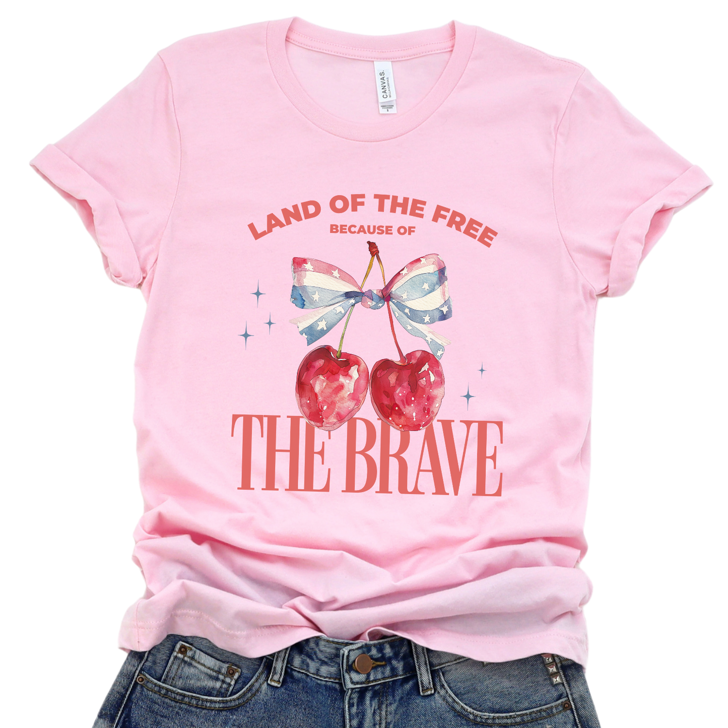 Pink t-shirt with cherry design and text on a white background.  Land of the Free because of the Brave
