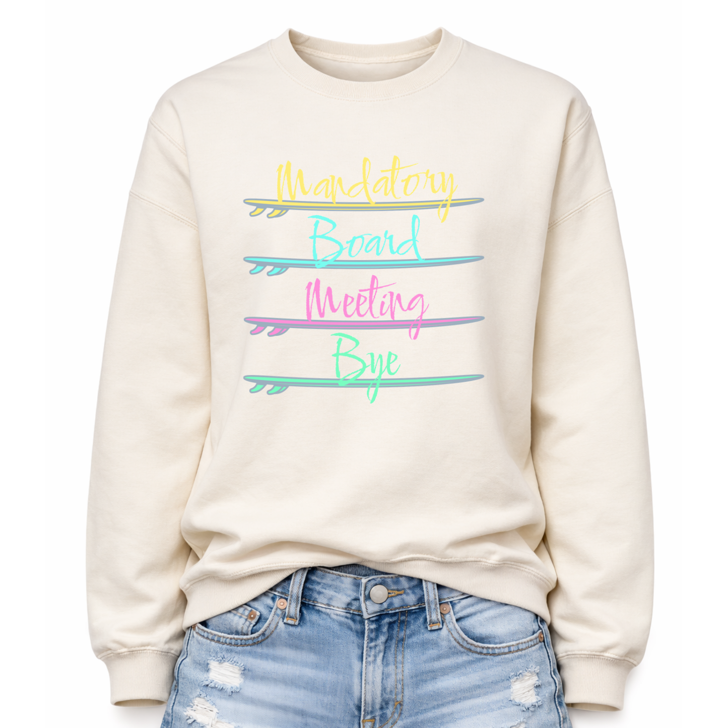Beach humor graphic on a classic off white crewneck sweatshirt. The design features stacked lettering that reads Mandatory Board Meeting Bye, with each word separated by illustrated surfboards that act as graphic dividers. The colorful surfboards create a playful coastal layout that reinforces the beach lifestyle theme.
