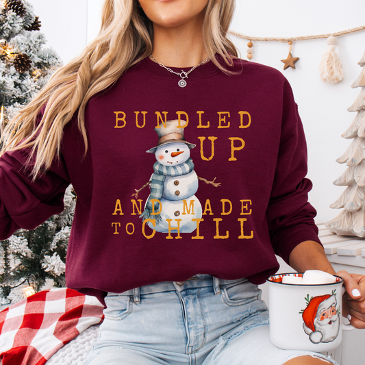 Bundled up and made to chill snowman on a maroon sweatshirt.