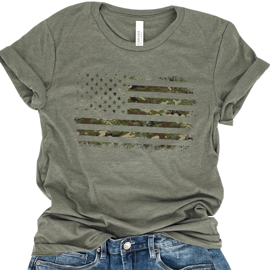 A green camouflage distressed American Flag graphic t-shirt displayed on a model with blue jeans.