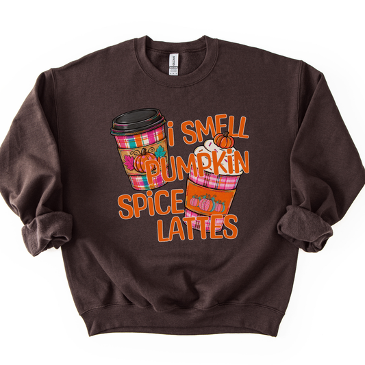 I smell pumpkin spice lattes featuring two coffee cups in fall plaid bright colors, orange, pink and teal with pumpkins on the sleeves of the cup warmers. Chocolate sweatshirt