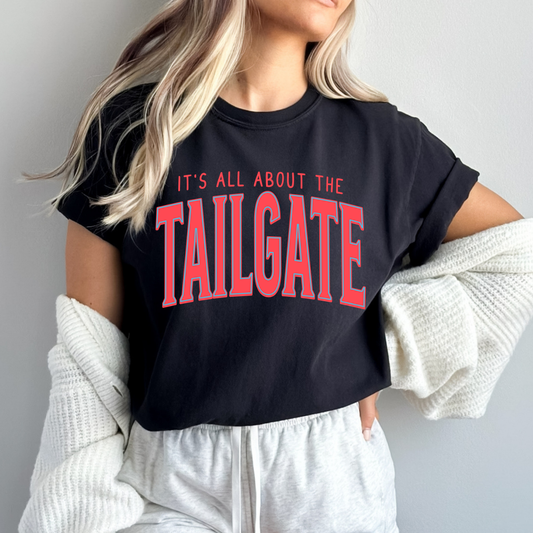 Person wearing a black t-shirt with 'It's All About the Tailgate' text in red.