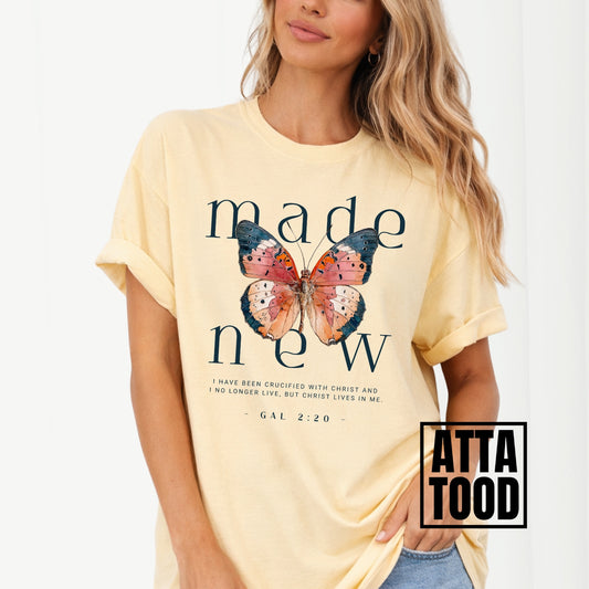 Woman wearing a yellow t-shirt with a butterfly graphic and text, brand 'Atta Tood' visible. Made new Galatians 2:20
