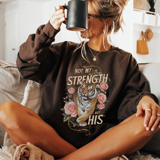 Not my Strength but his with a graphic of a tiger and pink roses on a chocolate sweatshirt