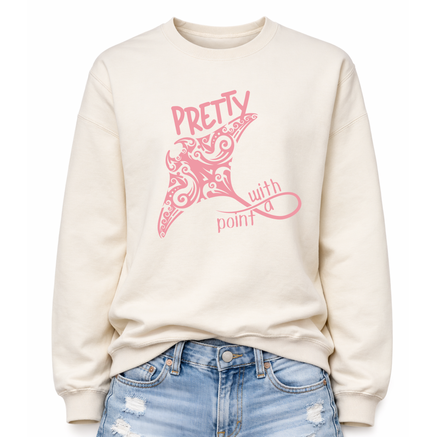 Coastal sea life graphic on a classic off white crewneck sweatshirt. The design features a large manta ray illustration filled with decorative swirl and coastal pattern details that create a textured ocean inspired look. The phrase Pretty With A Point is integrated with the graphic, with bold lettering above the manta ray and flowing script below, forming a balanced sea life layout that reads clearly from a distance.