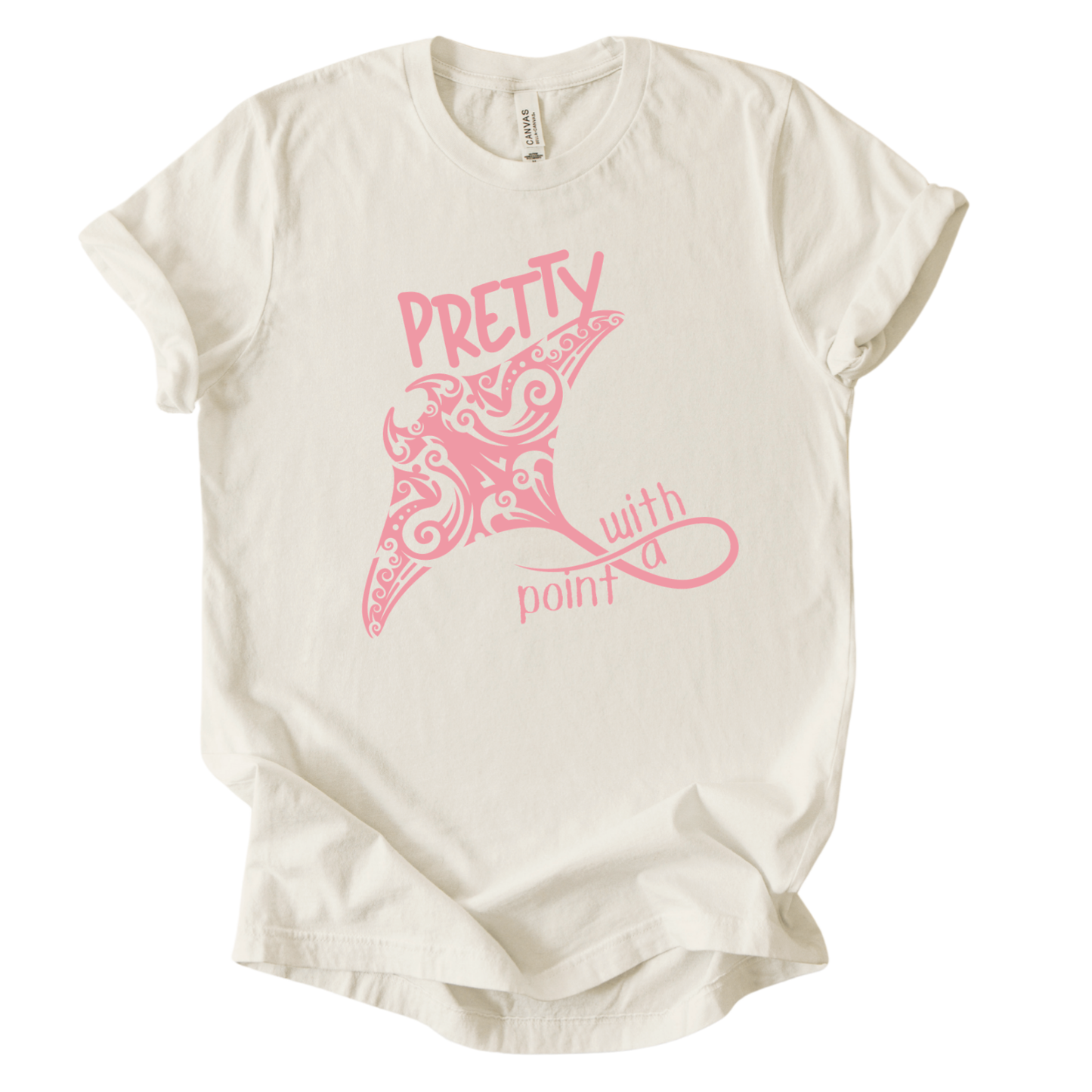 Coastal ocean graphic on a soft unisex heather oatmeal graphic tee. The design features a large manta ray illustration filled with decorative swirl and coastal pattern details that give the sea life artwork a textured, ocean inspired look. The phrase Pretty With A Point appears integrated into the graphic, with bold lettering above the manta ray and flowing script below, creating a balanced coastal themed layout.