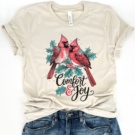 Beige t-shirt with cardinals and 'Comfort & Joy' text on a white background