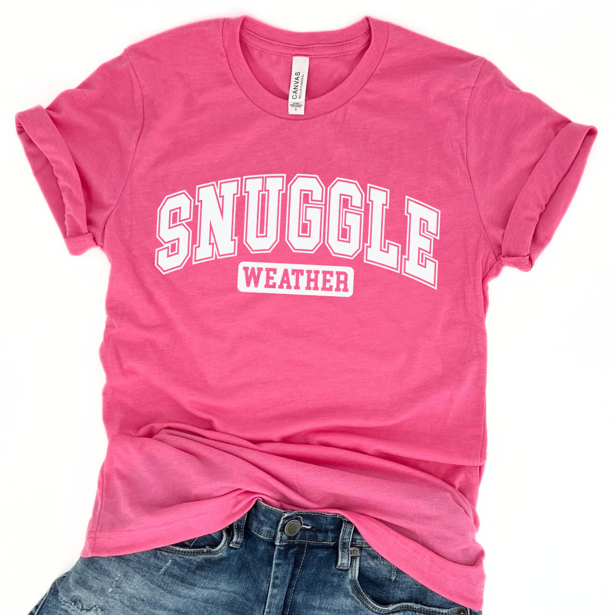 snuggle weather white graphic on a heather pink t-shirt