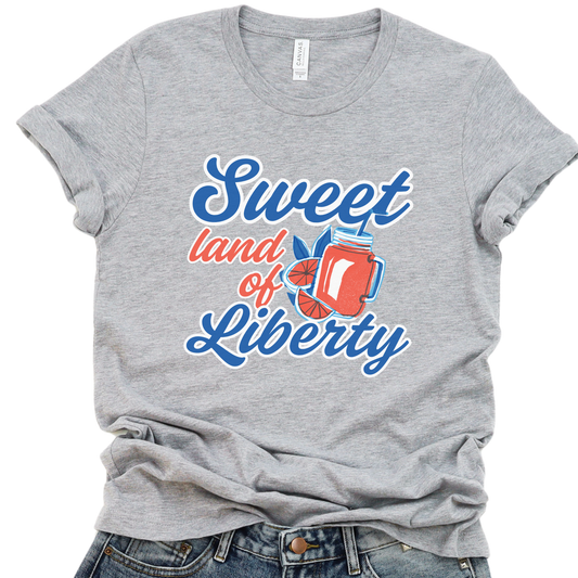 A gray t-shirt with a graphic that reads 'Sweet land of Liberty' accompanied by an image of an American flag and a freedom bell.