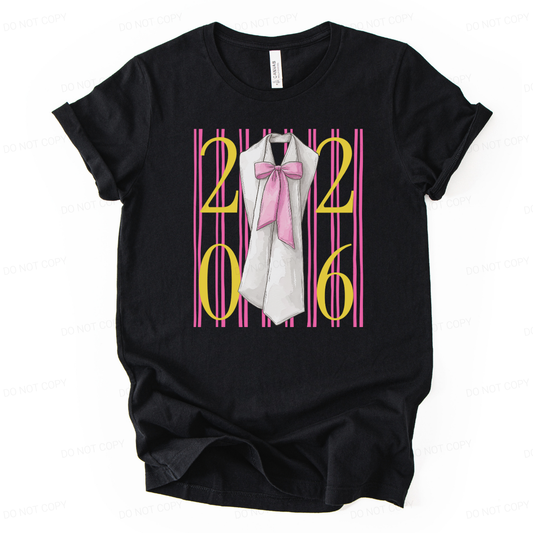 Graduation 2026 preppy themed black graphic t shirt. The design features bold 2026 lettering layered over vertical pink stripes, centered with a graduation sash illustration accented by a soft pink bow. The bright color contrast and feminine detailing create a standout senior year statement with clear Class of 2026 visibility and trend driven appeal.