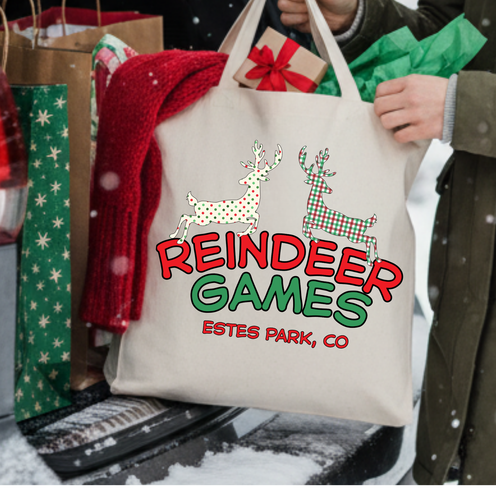 Canvas tote bag with 2 large reindeers.  One is white with red and green polka dots and the other one is red and green plaid.  Tote says reindeer games.  Customizable tote with business name, city and state or both