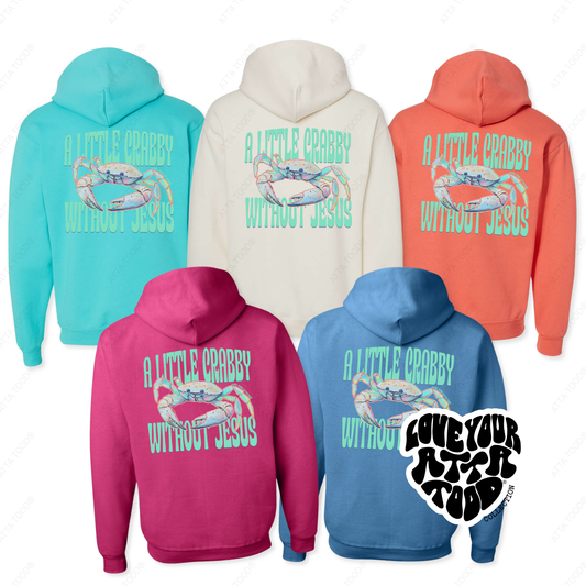 5 Jerzees® hoodies in the color of cyber pink, scuba blue, sweet cream, sunset coral and columbia blue.  The back of the hoodie has a graphic of a colorful tropical crab that says a little crabby without Jesus.