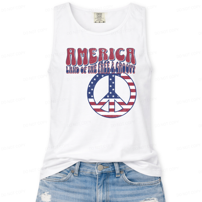White tank top with 'America Land of the Free & Groovy' text and peace symbol design on a white background.