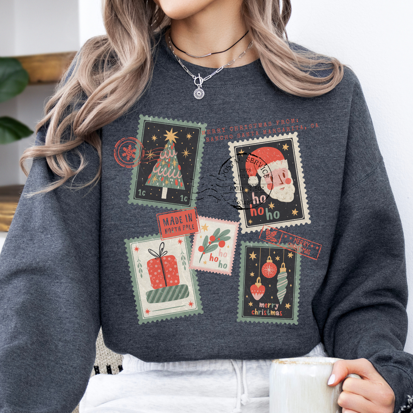 Christmas stamps scattered across a dark gray sweatshirt.  Customize with your town, state, business, or all.