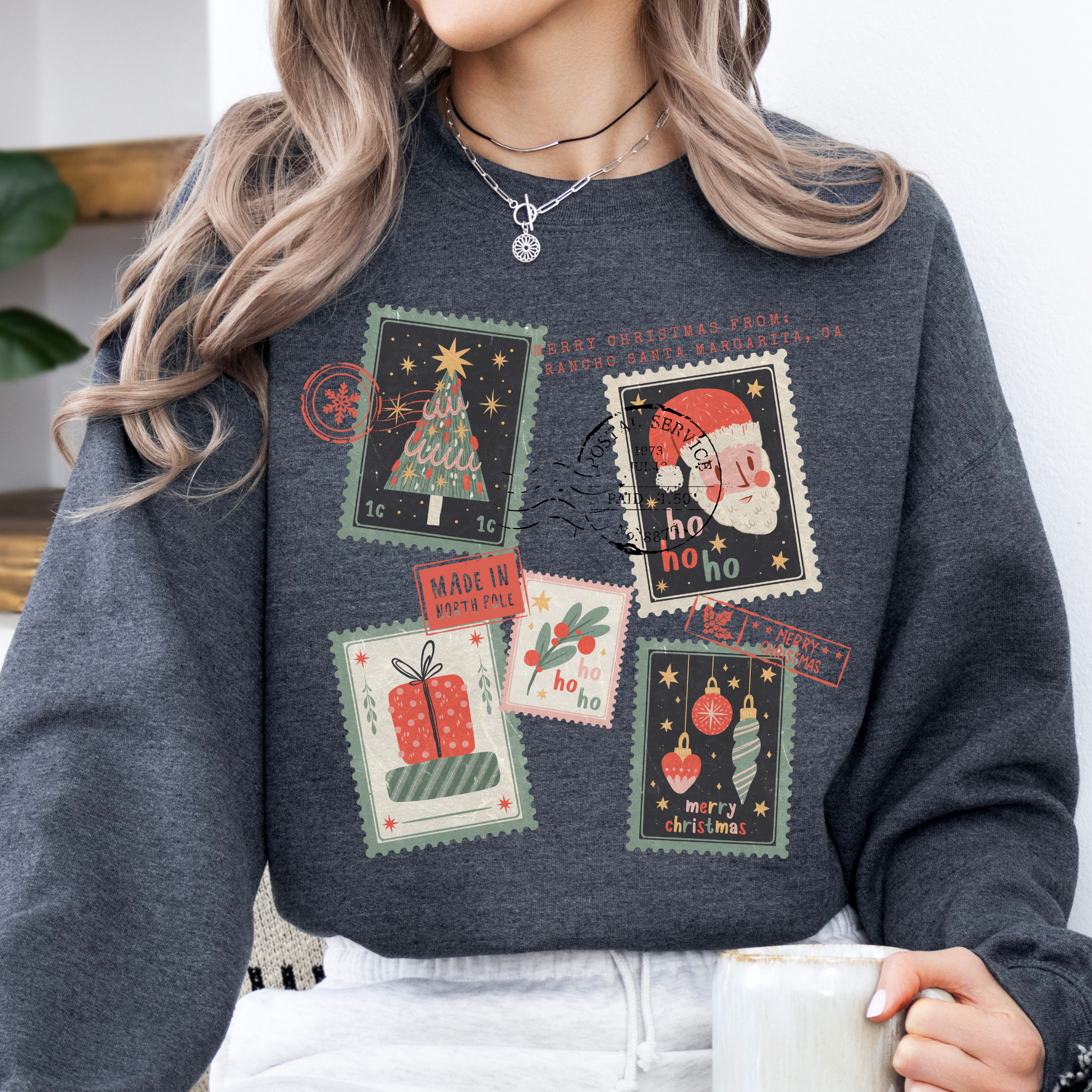 Christmas stamps scattered across a dark gray sweatshirt.  Customize with your town, state, business, or all.
