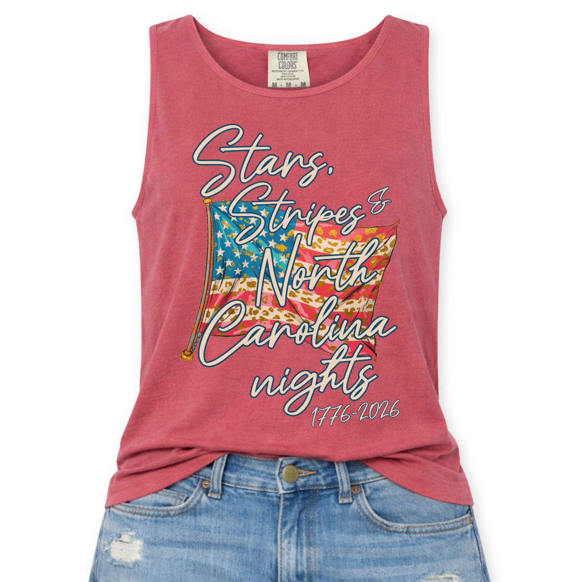 Comfort Colors tank top featuring a patriotic American flag graphic with mixed stripe patterns and script text reading “Stars, Stripes & Indiana nights” with “1776–2026” underneath, styled with light wash denim jeans.
