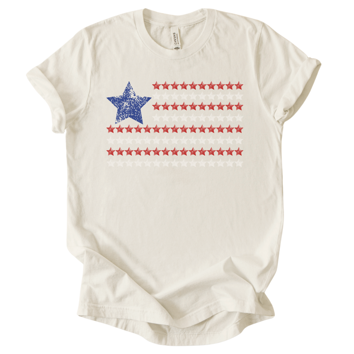 Patriotic Americana flag graphic on a cream t-shirt. The design features a distressed blue star positioned at the top left, paired with horizontal rows of red stars forming a flag-inspired layout. Soft weathered textures give the graphic a vintage, worn-in look while keeping the overall style clean and modern. The simple star-based flag design makes this an easy, everyday patriotic piece for Fourth of July, summer holidays, and Americana-themed collections.