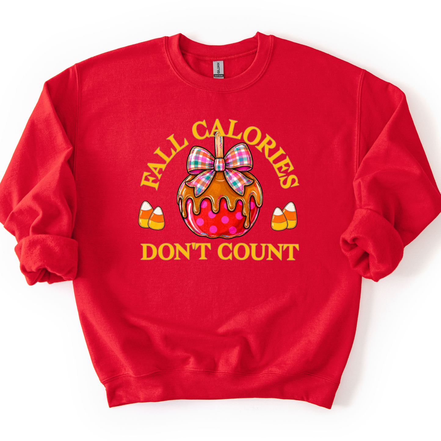 Fall calories don't count featuring a cute candy apple with a fall plaid ribbon. Cute little candy corns accent the sides of the large candy apple. Red sweatshirt