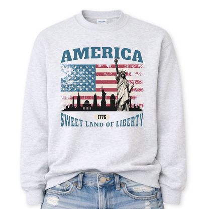 ash gray sweatshirt with American flag and Statue of Liberty design on a white background.  America, 1776 Sweet Land Of Liberty saying