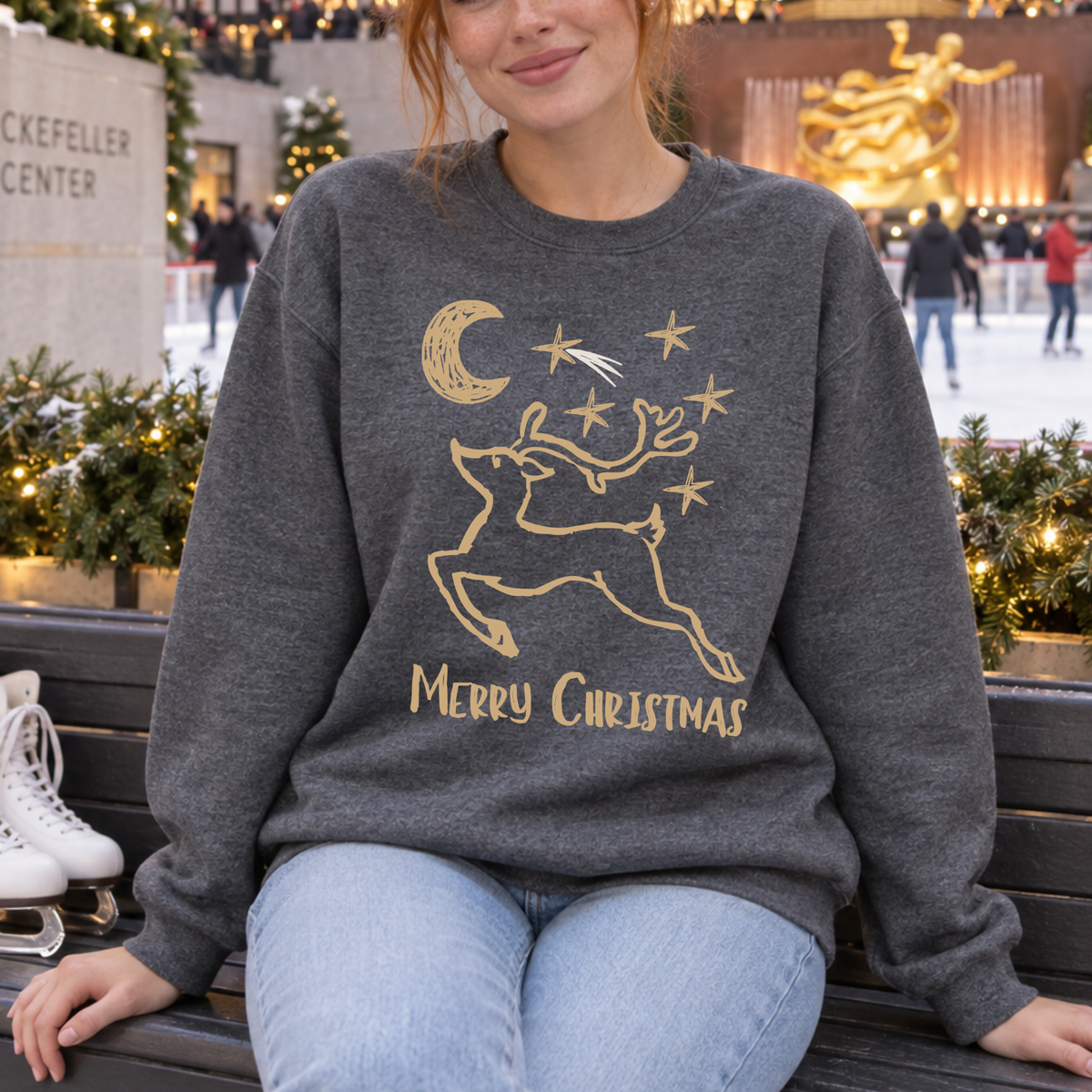 A vintage-inspired reindeer design with stars, a crescent moon, and a simple Merry Christmas message on a dark heather sweatshirt