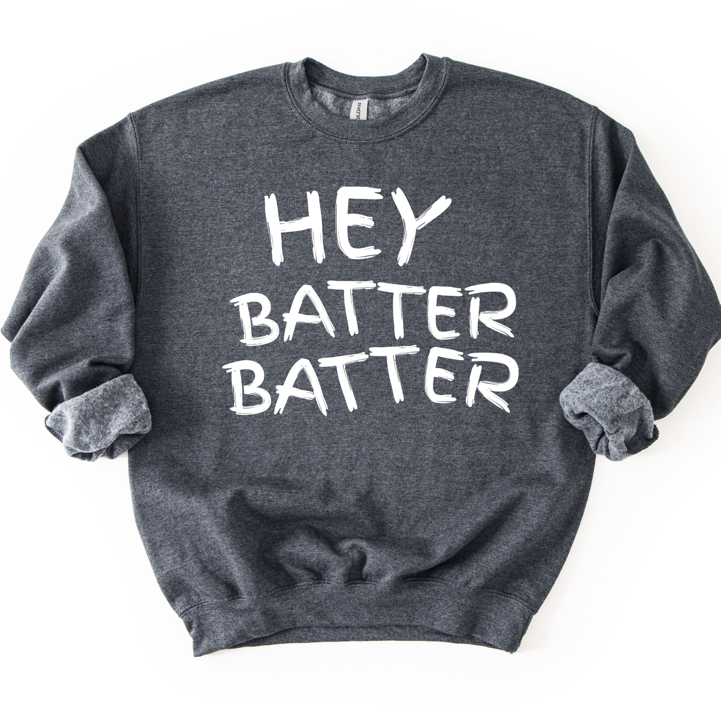 Dark heather gray crewneck sweatshirt with white hand-drawn style lettering reading “Hey Batter Batter,” styled flat with sleeves scrunched