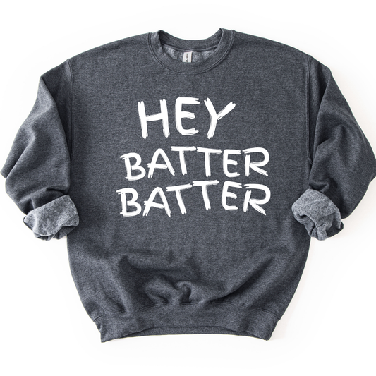 Dark heather gray crewneck sweatshirt with white hand-drawn style lettering reading “Hey Batter Batter,” styled flat with sleeves scrunched