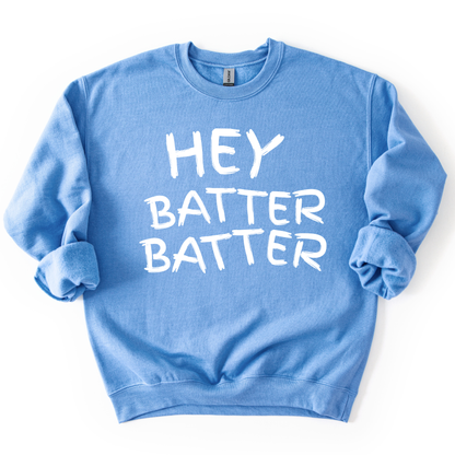 blue crewneck sweatshirt with white hand-drawn style lettering reading “Hey Batter Batter,” styled flat with sleeves scrunched
