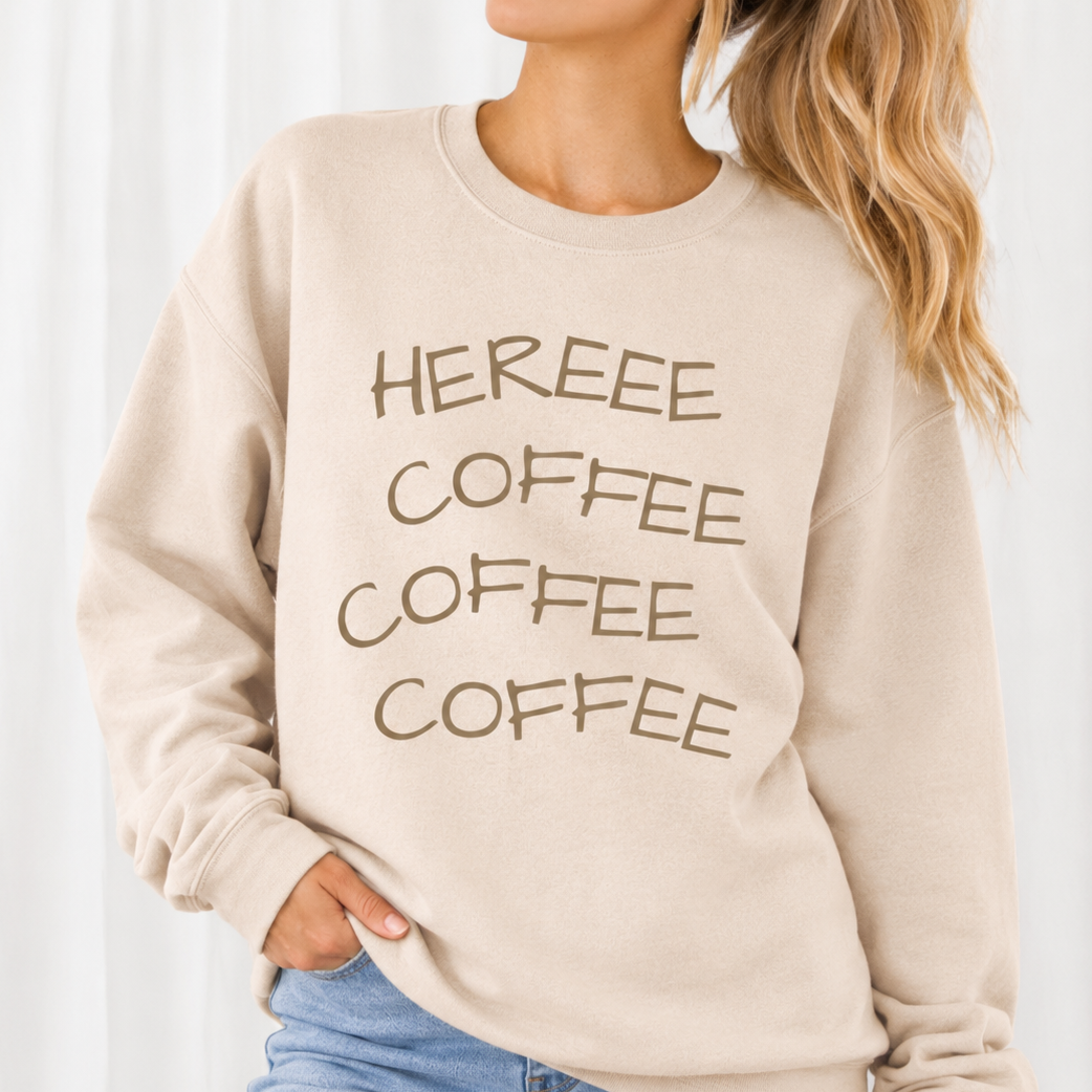 Beige sweatshirt with 'HEREEE COFFEE COFFEE COFFEE' text worn by a person on a white background