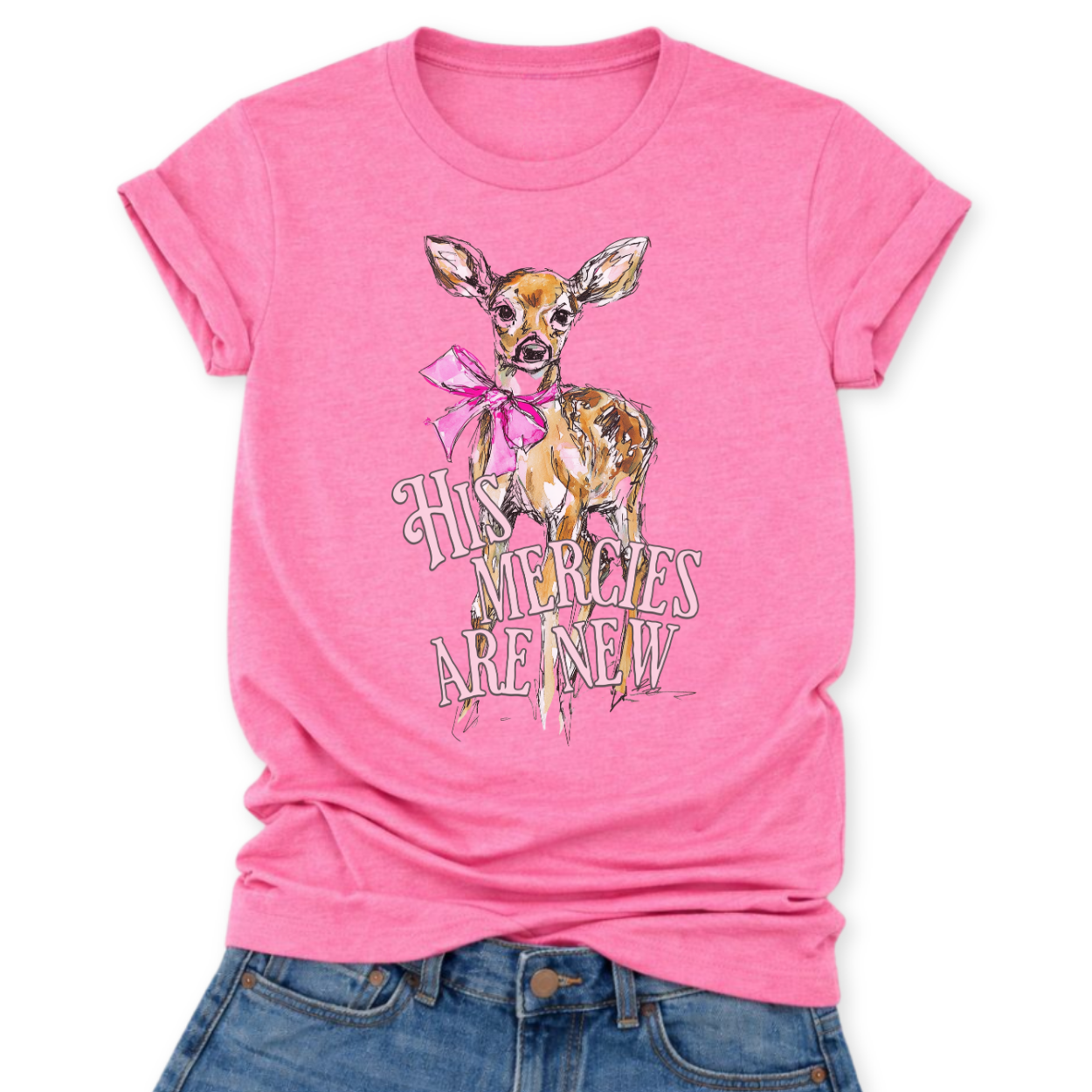 Christian Easter scripture graphic on a Bella Canvas t-shirt. The design features an illustrated fawn with soft watercolor-style detailing, accented with a bright pink bow for a feminine spring touch. The phrase “His Mercies Are New” appears in vintage-inspired lettering beneath the deer, referencing Lamentations 3:23 and the renewal message of Easter.